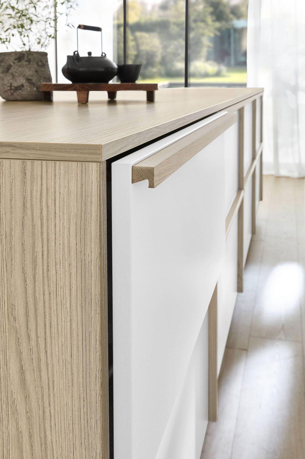 Detail einer Nobilia Japandi Küche mit integrierter Griffleiste, weißer Front und heller Holzstruktur.